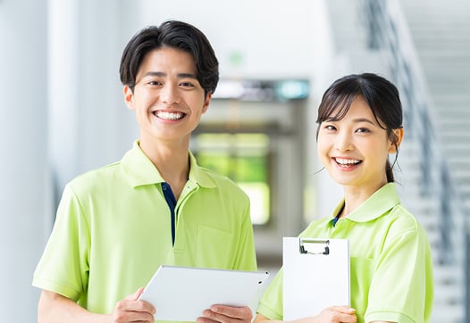 男性と女性のスタッフが正面をみて微笑んでいる